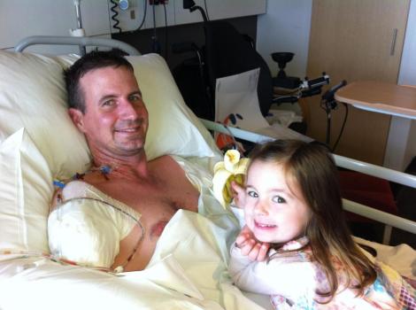 Matthew being fed a post-surgery banana by Emily.